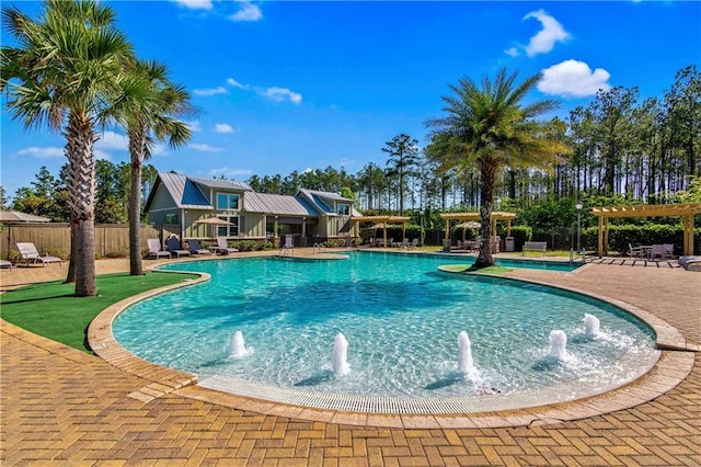 view of pool with pool water feature, a patio, and a pergola