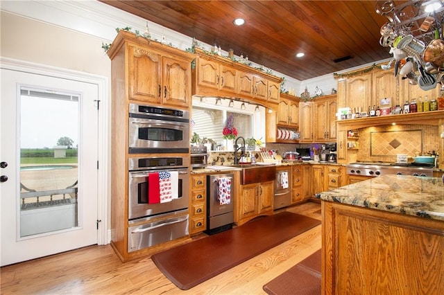 kitchen featuring double oven, light stone countertops, light hardwood / wood-style floors, tasteful backsplash, and dishwasher