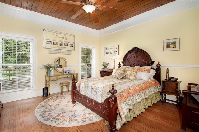 bedroom with ceiling fan, hardwood / wood-style floors, wooden ceiling, and crown molding