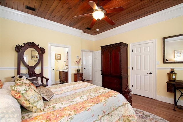 bedroom featuring wood ceiling, ensuite bath, wood-type flooring, ceiling fan, and crown molding