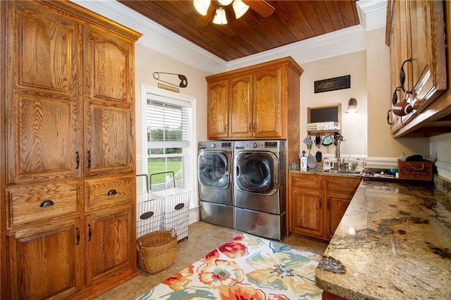 washroom featuring ceiling fan, washer and dryer, crown molding, and light tile patterned floors