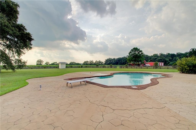 view of swimming pool with a lawn, a diving board, and a patio