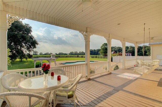 wooden deck featuring ceiling fan, a pergola, and a yard