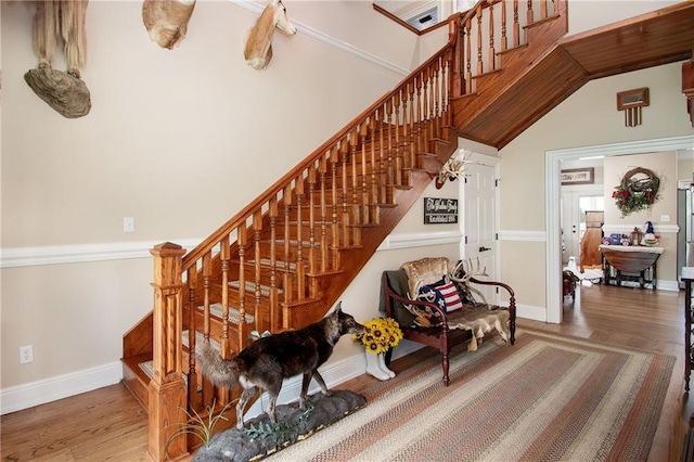 stairway featuring hardwood / wood-style floors and a towering ceiling