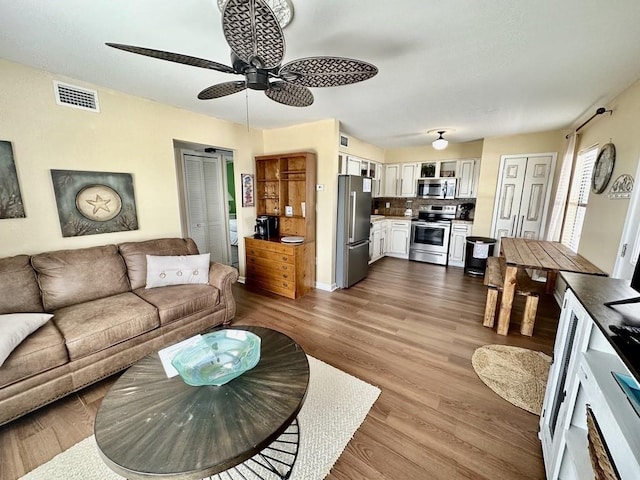 living room with ceiling fan and dark hardwood / wood-style floors