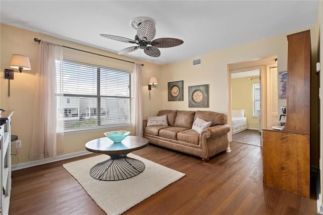 living room featuring ceiling fan and dark hardwood / wood-style floors