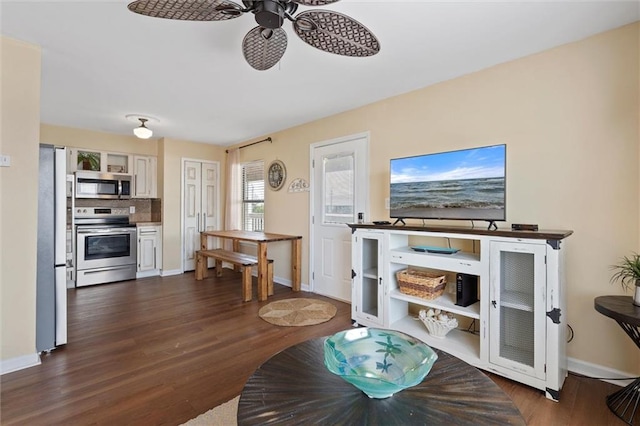 living room featuring ceiling fan and dark wood-type flooring