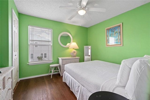 bedroom with dark hardwood / wood-style flooring, ceiling fan, a closet, and a textured ceiling