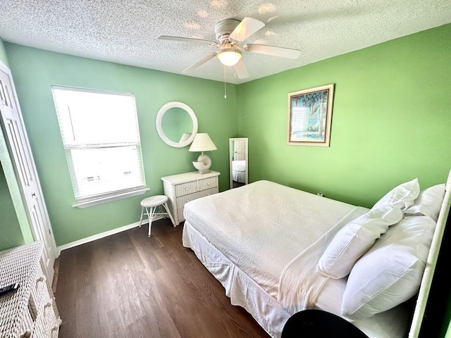 bedroom featuring dark hardwood / wood-style flooring, ceiling fan, and a textured ceiling