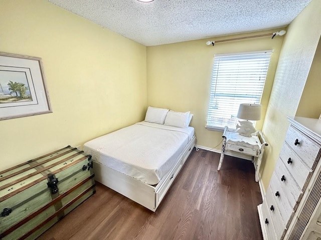 bedroom with a textured ceiling and dark hardwood / wood-style floors