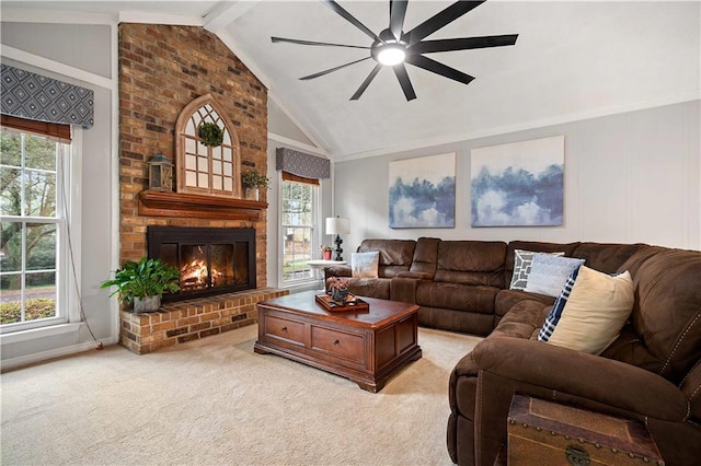 carpeted living room with lofted ceiling with beams, a wealth of natural light, and a fireplace