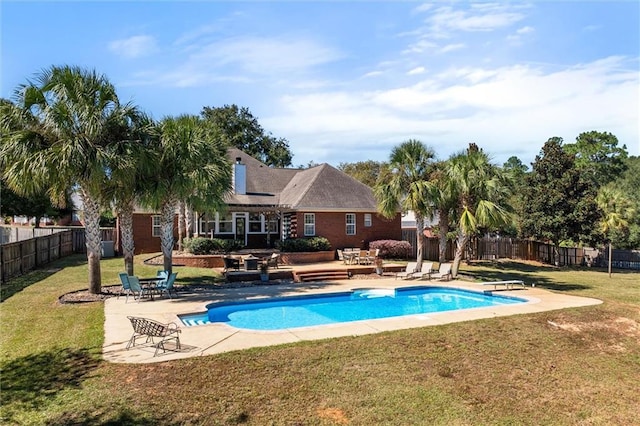 view of pool with a patio area, a lawn, and a diving board