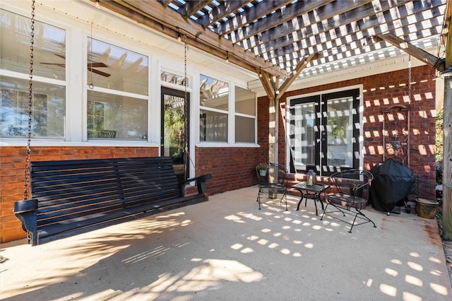 view of patio with area for grilling and a pergola