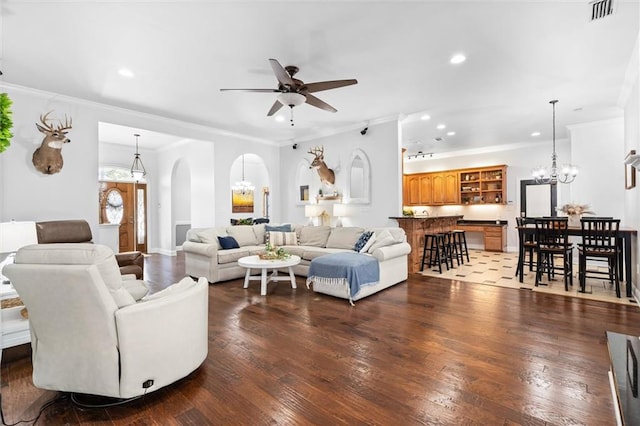 living room featuring crown molding, hardwood / wood-style floors, and ceiling fan with notable chandelier