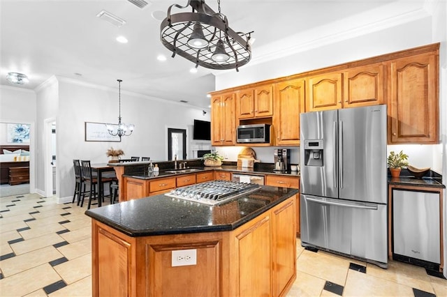 kitchen with kitchen peninsula, an inviting chandelier, stainless steel appliances, pendant lighting, and a center island