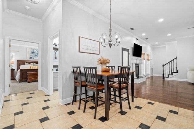 dining space with crown molding, an inviting chandelier, and light hardwood / wood-style floors