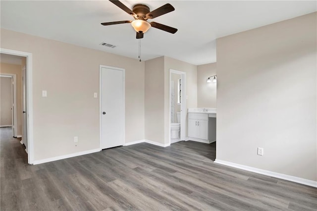 unfurnished bedroom featuring ceiling fan, dark hardwood / wood-style flooring, and ensuite bath