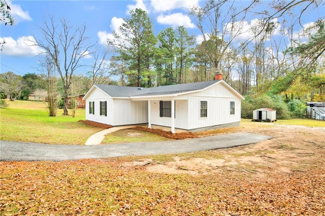 view of front of property featuring a front yard and a storage unit