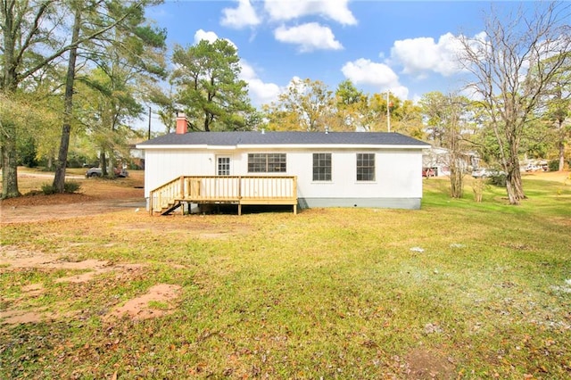 back of property with a deck and a lawn