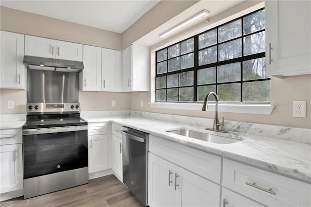 kitchen featuring sink, white cabinetry, light stone countertops, and appliances with stainless steel finishes