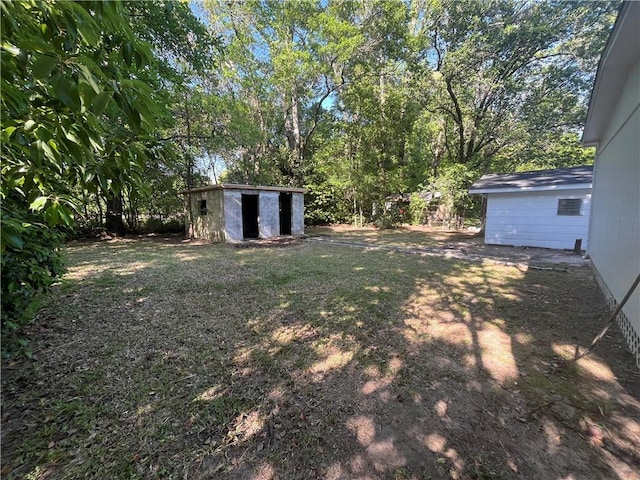 view of yard with a storage shed and an outbuilding