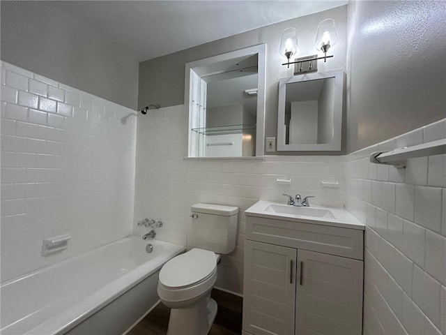 bathroom with vanity, tile walls, toilet, and shower / bathtub combination