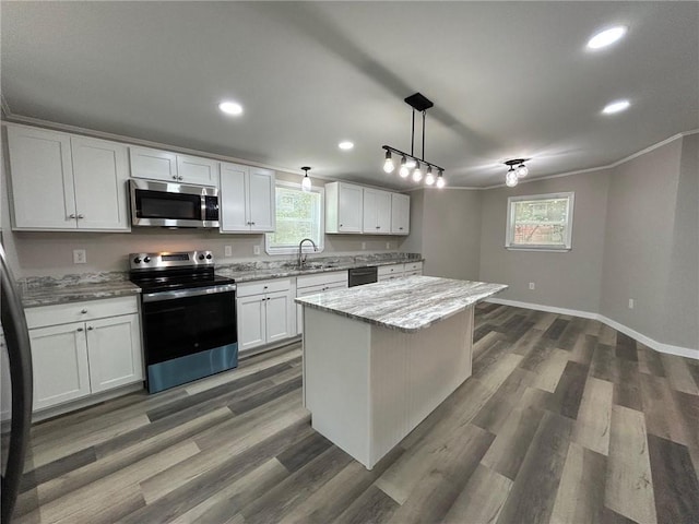 kitchen featuring light stone countertops, a sink, baseboards, stainless steel appliances, and recessed lighting