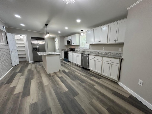 kitchen with appliances with stainless steel finishes, ornamental molding, recessed lighting, and white cabinetry