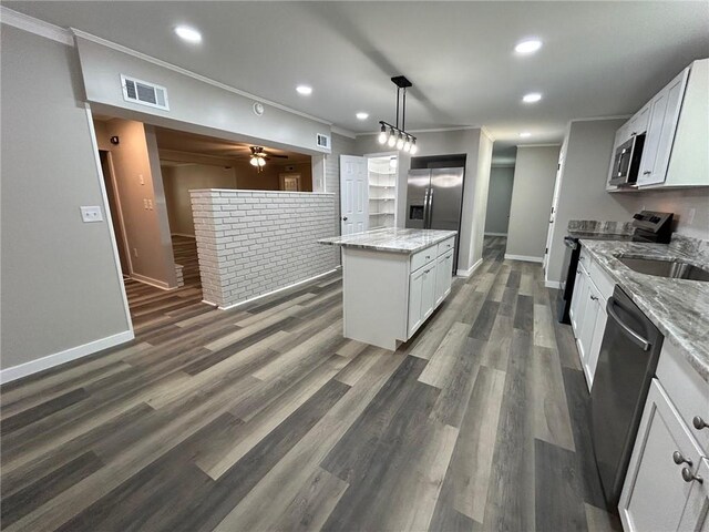 kitchen with visible vents, baseboards, appliances with stainless steel finishes, and a kitchen island