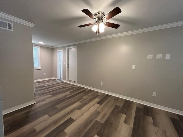 empty room featuring crown molding, ceiling fan, baseboards, visible vents, and dark wood-style floors