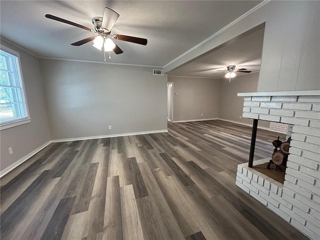 unfurnished living room featuring a brick fireplace, ceiling fan, visible vents, and ornamental molding