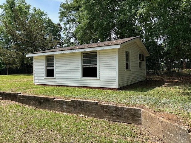 view of property exterior with fence and a lawn