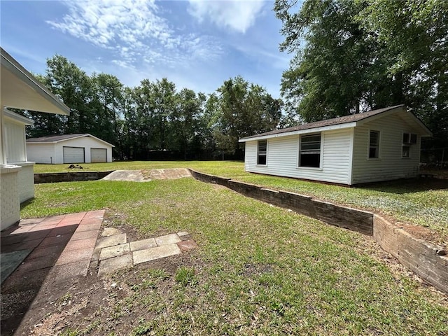 view of yard featuring a garage and an outdoor structure