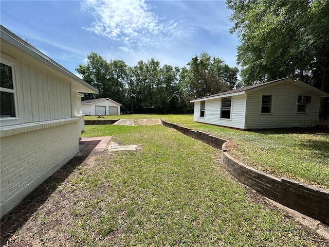 view of yard featuring a detached garage and an outdoor structure
