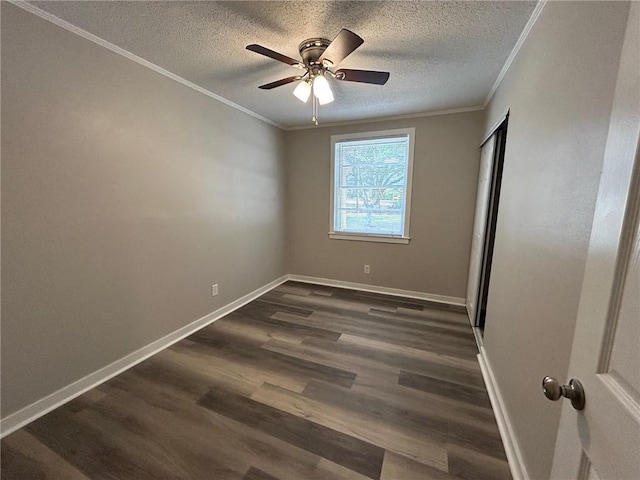unfurnished bedroom featuring crown molding, a textured ceiling, baseboards, and dark wood-style floors