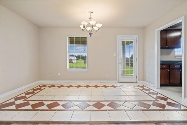 10966 Brighton Dr W, Chunchula, AL 36521 - unfurnished dining area featuring a chandelier, baseboards, light tile patterned floors, and inlaid floor details