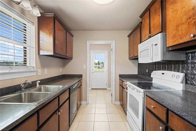 10966 Brighton Dr W, Chunchula, AL 36521 - kitchen with white appliances, a sink, light tile patterned floors, decorative backsplash, and dark countertops