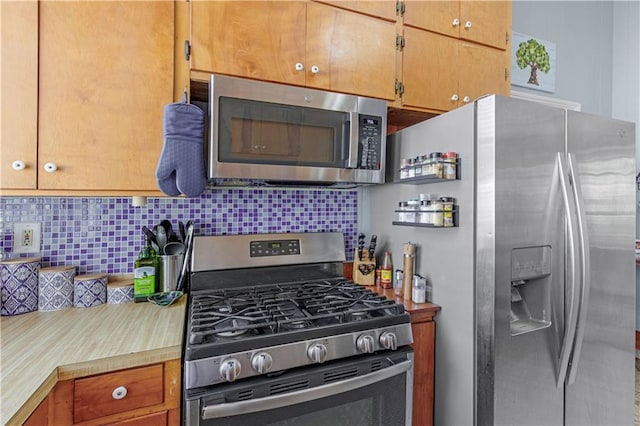 kitchen with appliances with stainless steel finishes, brown cabinetry, light countertops, and tasteful backsplash