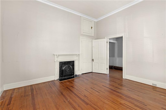 unfurnished living room with ornamental molding, dark wood finished floors, a high end fireplace, and baseboards