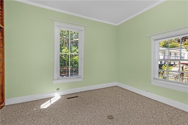 carpeted spare room with visible vents, crown molding, and baseboards