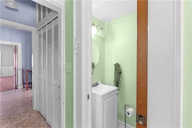 bathroom with a closet and vanity