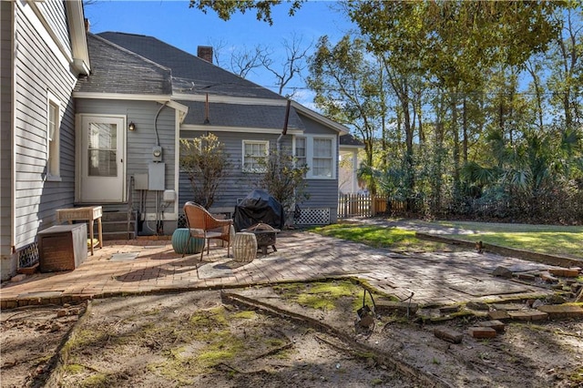 rear view of property with entry steps, an outdoor fire pit, a chimney, and a patio