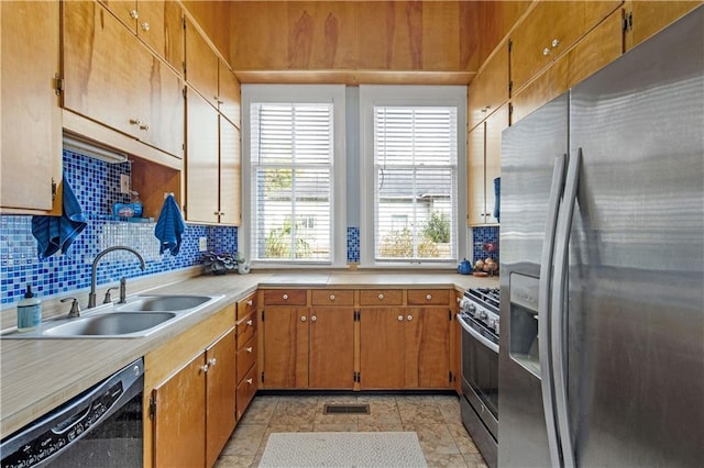 kitchen with stainless steel appliances, a sink, light countertops, backsplash, and brown cabinetry