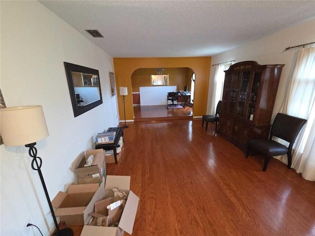 2460 Maple Dr, Mobile, AL 36695 - hallway featuring arched walkways, wood finished floors, and a textured ceiling