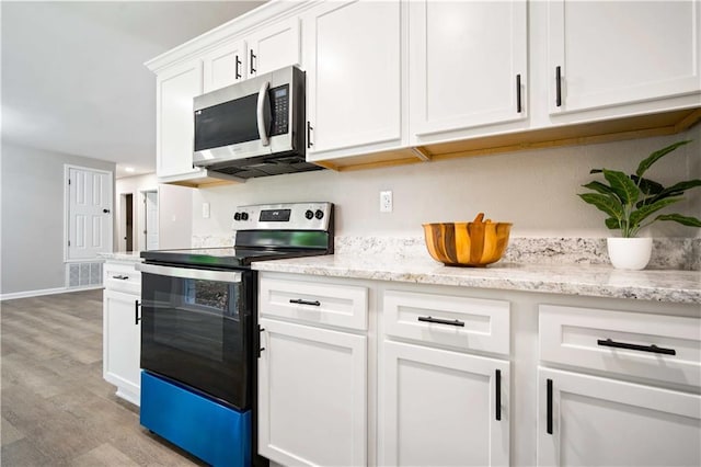 1513 Carlisle Dr W, Mobile, AL 36618 - kitchen with appliances with stainless steel finishes, light wood-style floors, white cabinetry, baseboards, and light stone counters