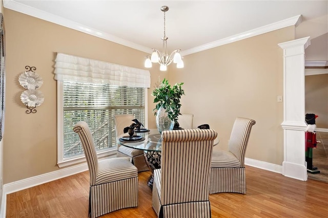 dining area with ornate columns, ornamental molding, a notable chandelier, and light wood-type flooring