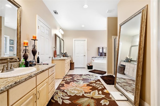 bathroom featuring tile patterned flooring, vanity, and a bath