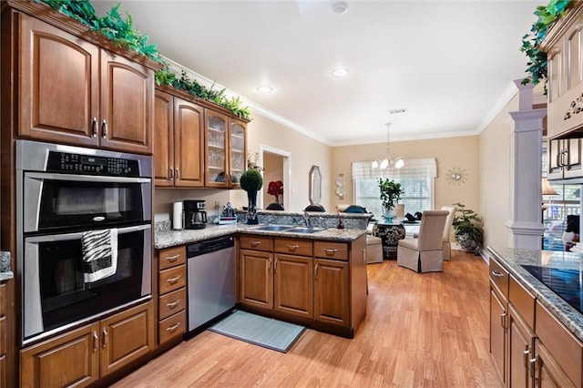 kitchen featuring stainless steel appliances, light stone counters, a notable chandelier, kitchen peninsula, and light wood-type flooring