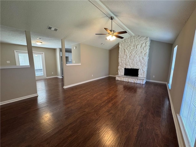 unfurnished living room featuring a stone fireplace, vaulted ceiling with beams, dark wood-type flooring, and ceiling fan