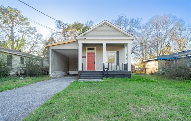 shotgun-style home featuring driveway, a front lawn, a porch, and an attached carport